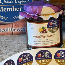 Load image into Gallery viewer, Jars of Taste of the West preserves with decorative cloths on a stone surface, surrounded by branded labels.